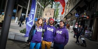 Three volters posing with a Volt flag and a flag of France