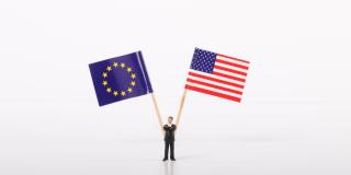 Businessman standing in front of flags of European Union and USA