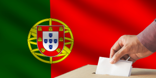 A Portuguese flag behind a person casting a vote