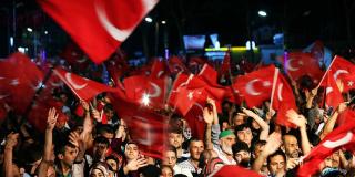 A crowd waves Turkish flags