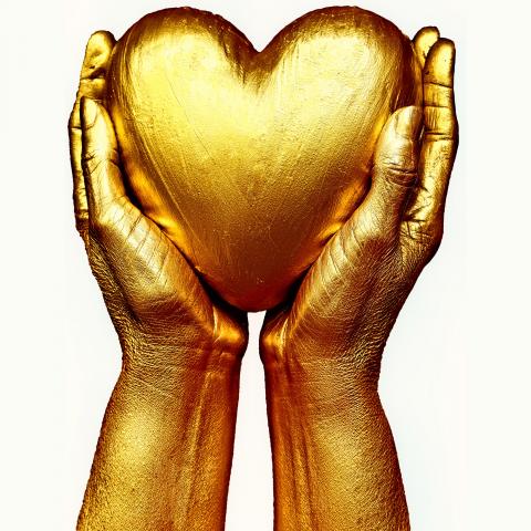 golden heart held in hands