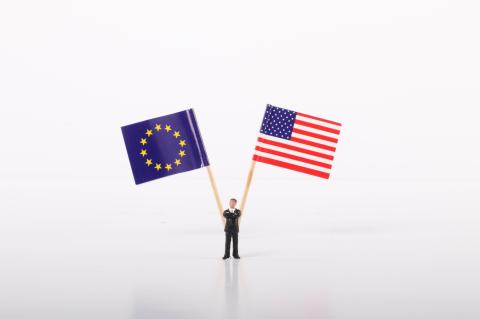 Businessman standing in front of flags of European Union and USA
