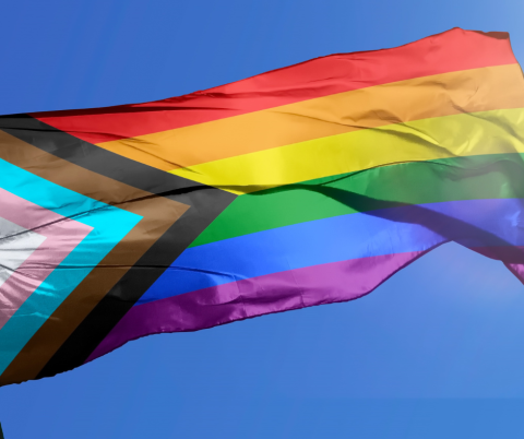 Progressive pride flag flies high in the sky