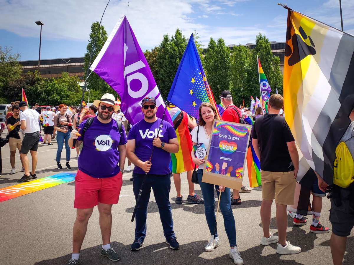 Three members of Volt Luxembourg with flags and posters